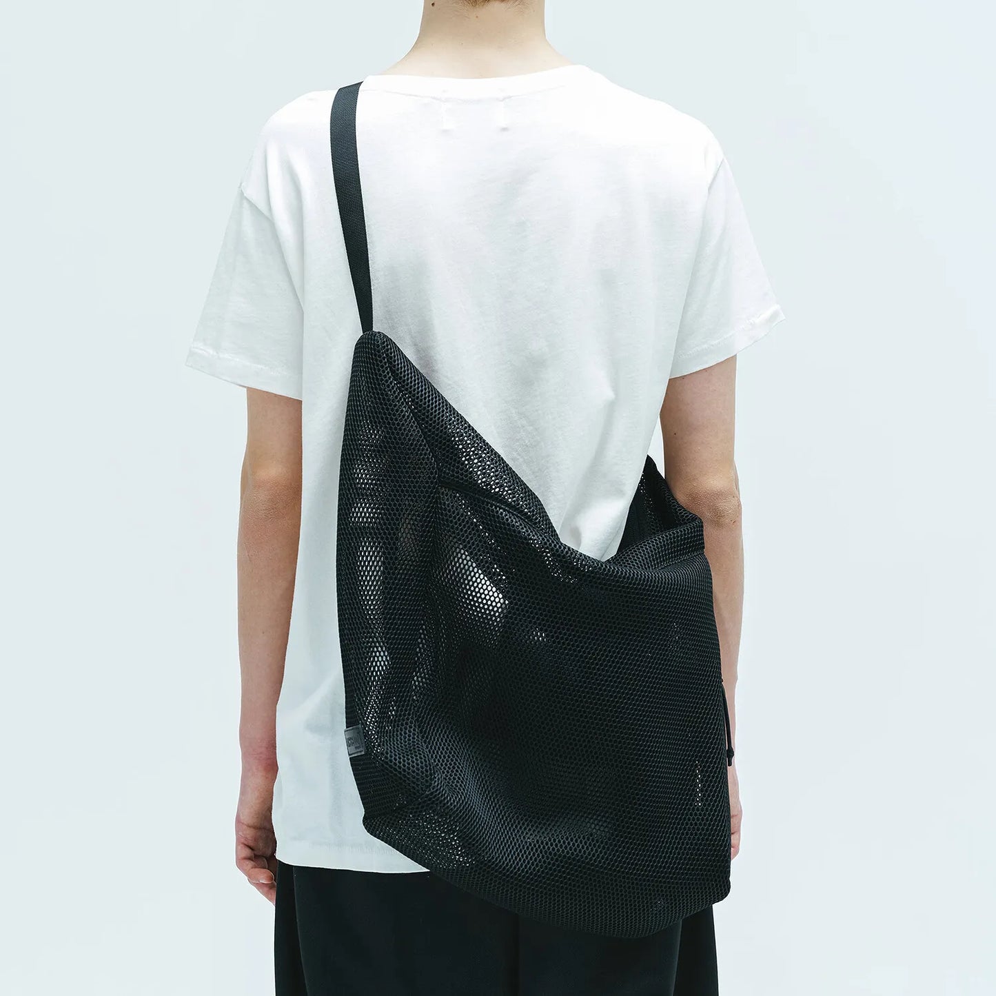 BAICYCLON(バイシクロン)のメッシュナイロン性ショルダーバッグ「BCL-28 MESH LARGE SHOULDER BAG」のBLACKの背面からの着用写真