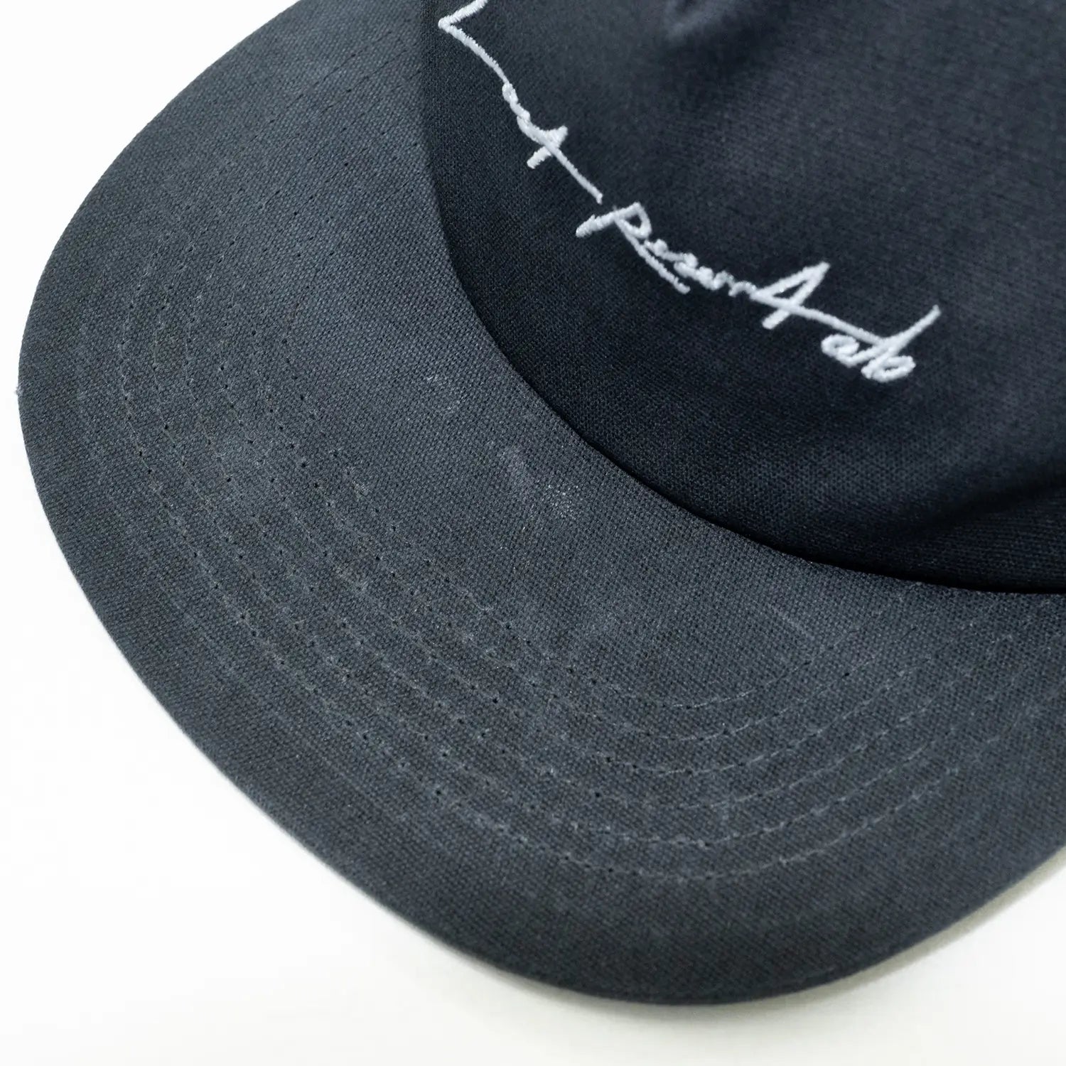 ユーズド加工が施されたハリのある「DARK NAVY」カラーのオイルキャンバス生地を使用したLast Resort AB(ラストリゾート)の5パネルキャップ「LOW CROWN 5PANEL CAP」のバイザー部分の写真