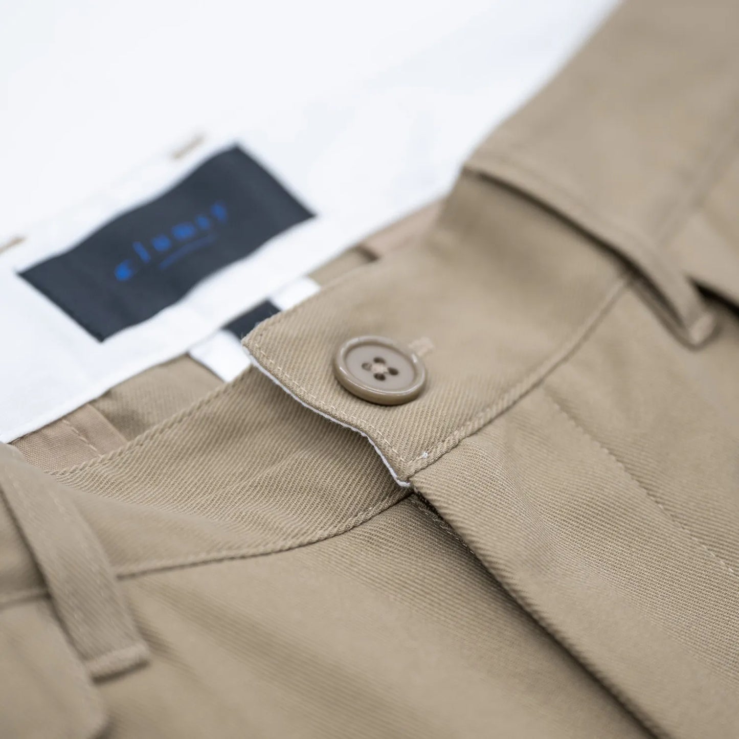 CLUMSY PICTURESの新作パンツ「2 PLEATS RELAXED TWILL PANTS」のBEIGEカラーの腰回りの商品写真
