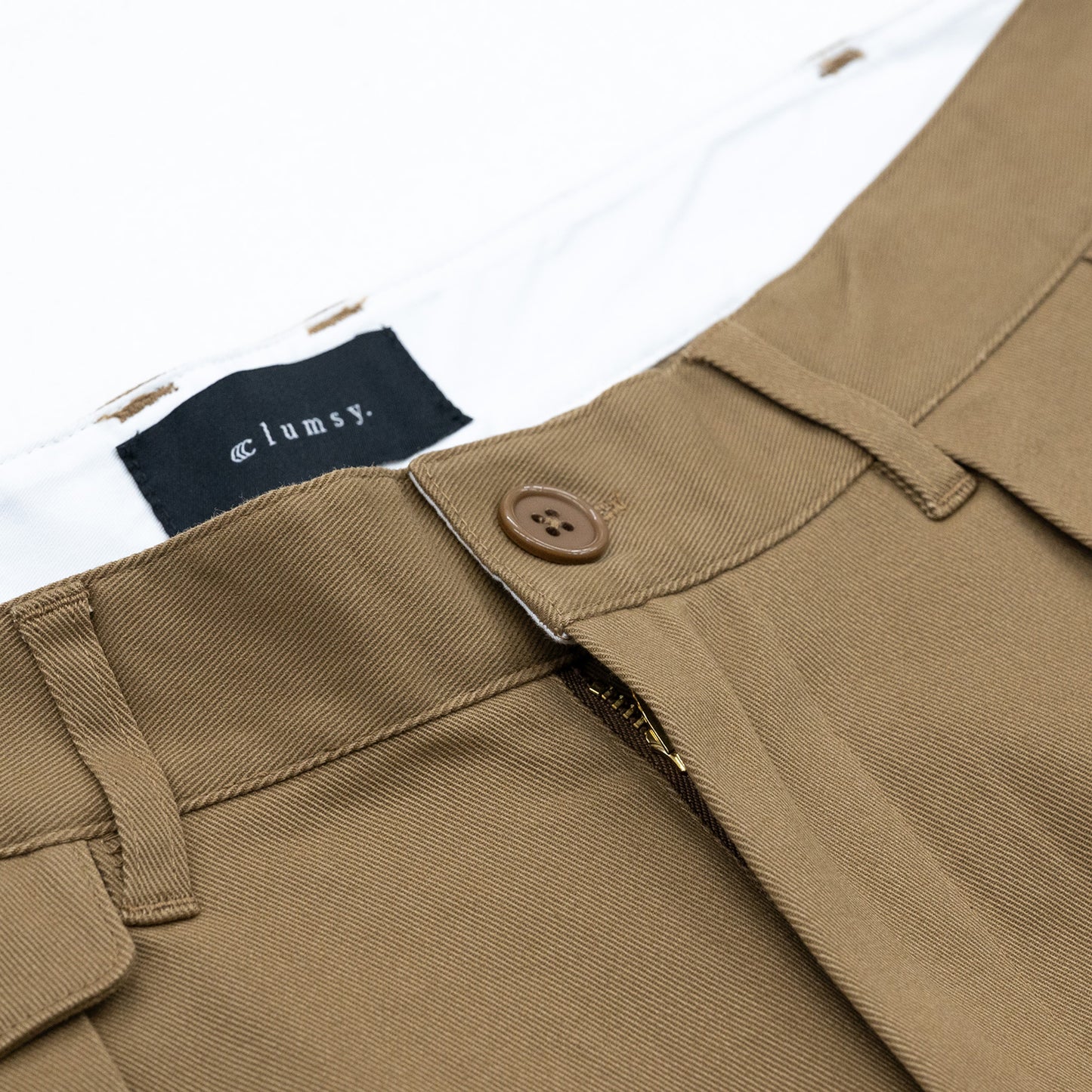 CLUMSY PICTURES(クラムジー)の名作パンツ「2 PLEATS RELAXED TWILL PANTS」の2025AWの新色「BROWNカラー」のウエスト部分の写真