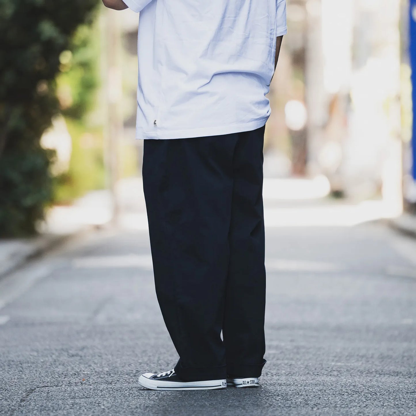 CLUMSY PICTURES(クラムジー)の名作パンツ「2 PLEATS RELAXED TWILL PANTS」の2025AWの新色「BROWNカラー」の左斜め後ろからの着用写真