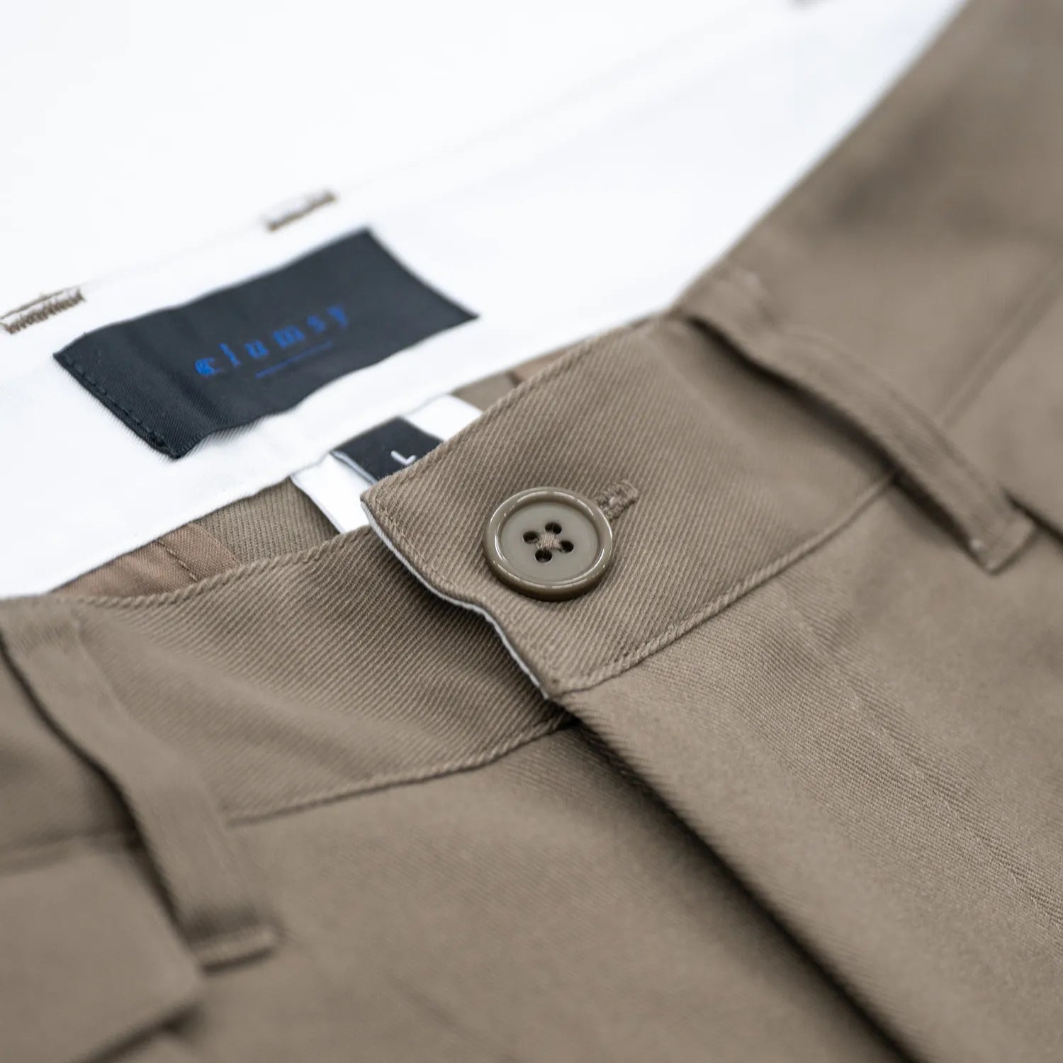 CLUMSY PICTURESの新作パンツ「2 PLEATS RELAXED TWILL PANTS」のOLIVE BROWNカラーの腰回りの商品写真