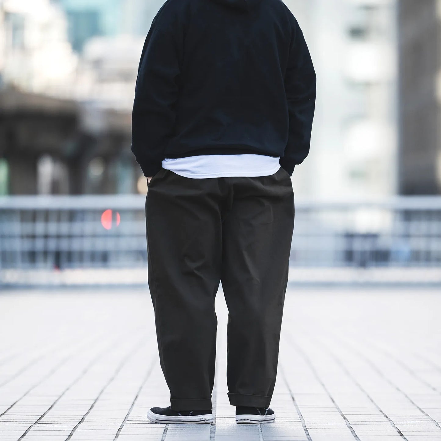 CLUMSY PICTURESの新作パンツ「2 PLEATS RELAXED TWILL PANTS」の背面からの着用写真