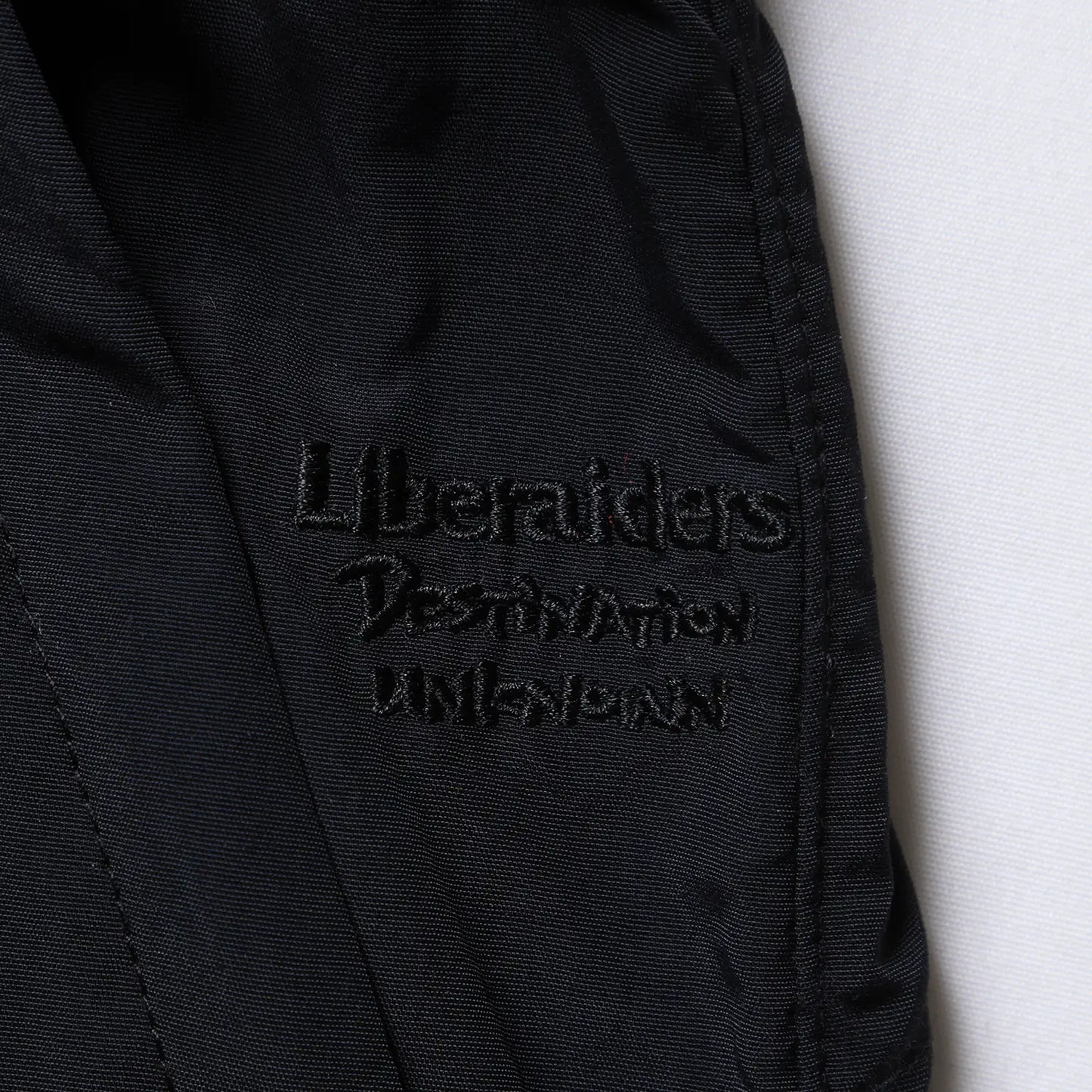 Liberaiders(リベレイダース)のサプレックスナイロン製のショーツ「SUPPLEX NYLON SHORTS」のBLACKカラーの刺繍デザインの写真