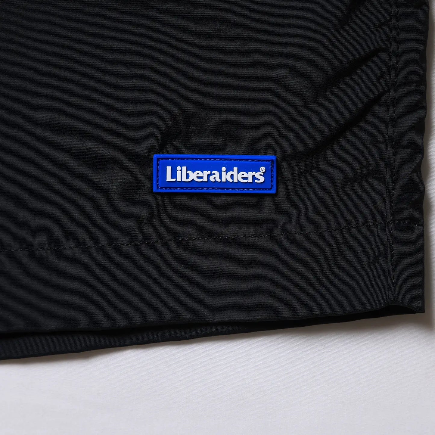 Liberaiders(リベレイダース)のサプレックスナイロン製のショーツ「SUPPLEX NYLON SHORTS」のBLACKカラーのブランドぱブランドパッチ写真