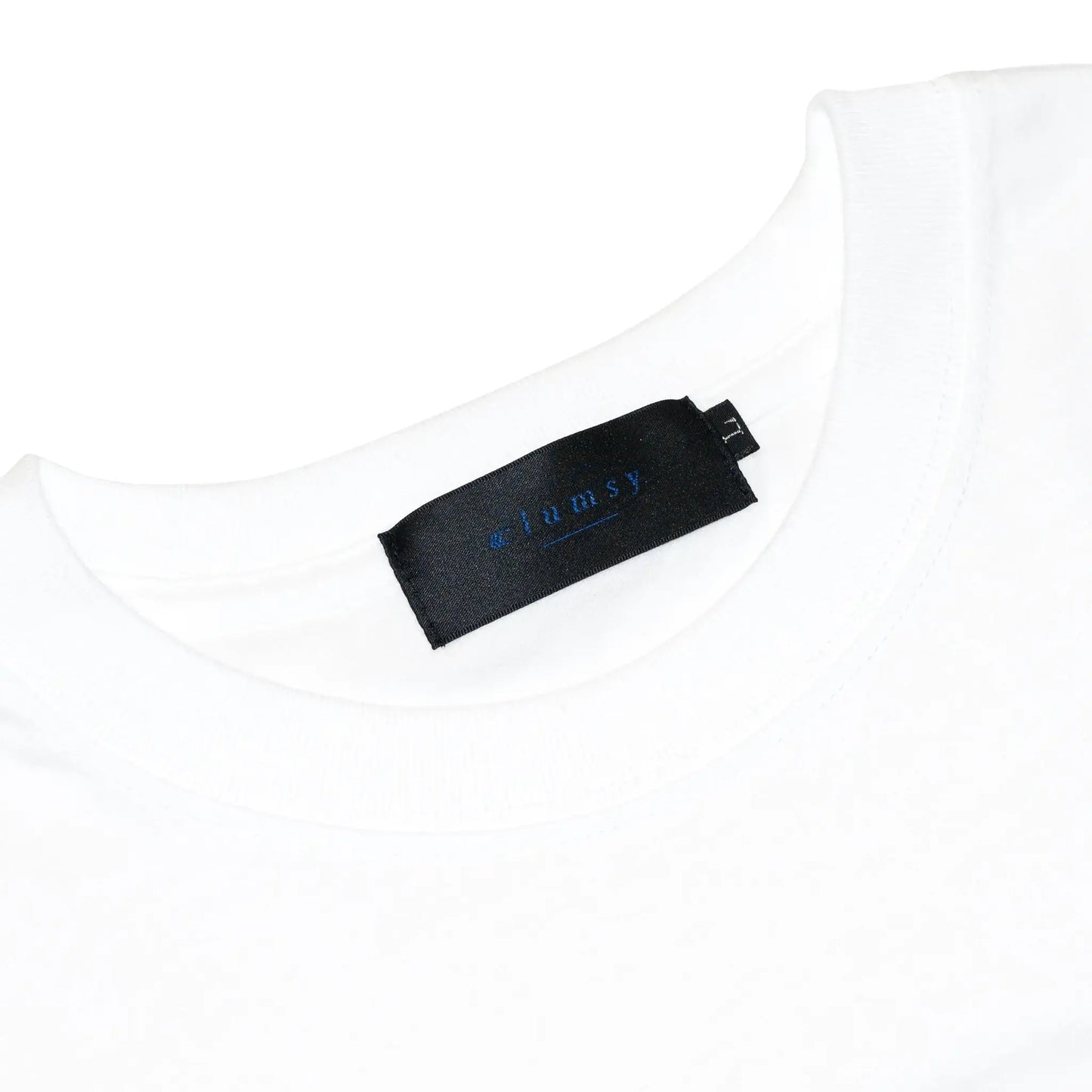 「CLUMSY PICTURES」のアイコン的デザインのロングスリーブTシャツ「LIMITED CCC L/S TEE」の「WHITE/OLD BLUE」カラーのブランドタグ写真