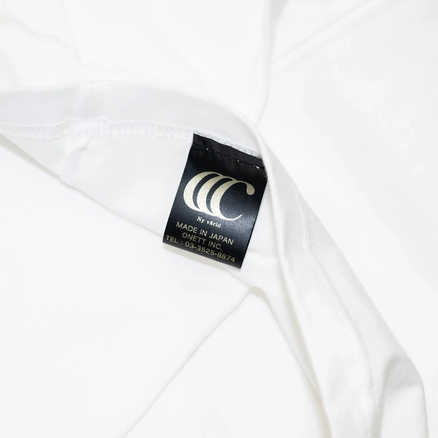 「CLUMSY PICTURES」のアイコン的デザインのロングスリーブTシャツ「LIMITED CCC L/S TEE」の「WHITE/OLD BLUE」カラーの折ネーム写真