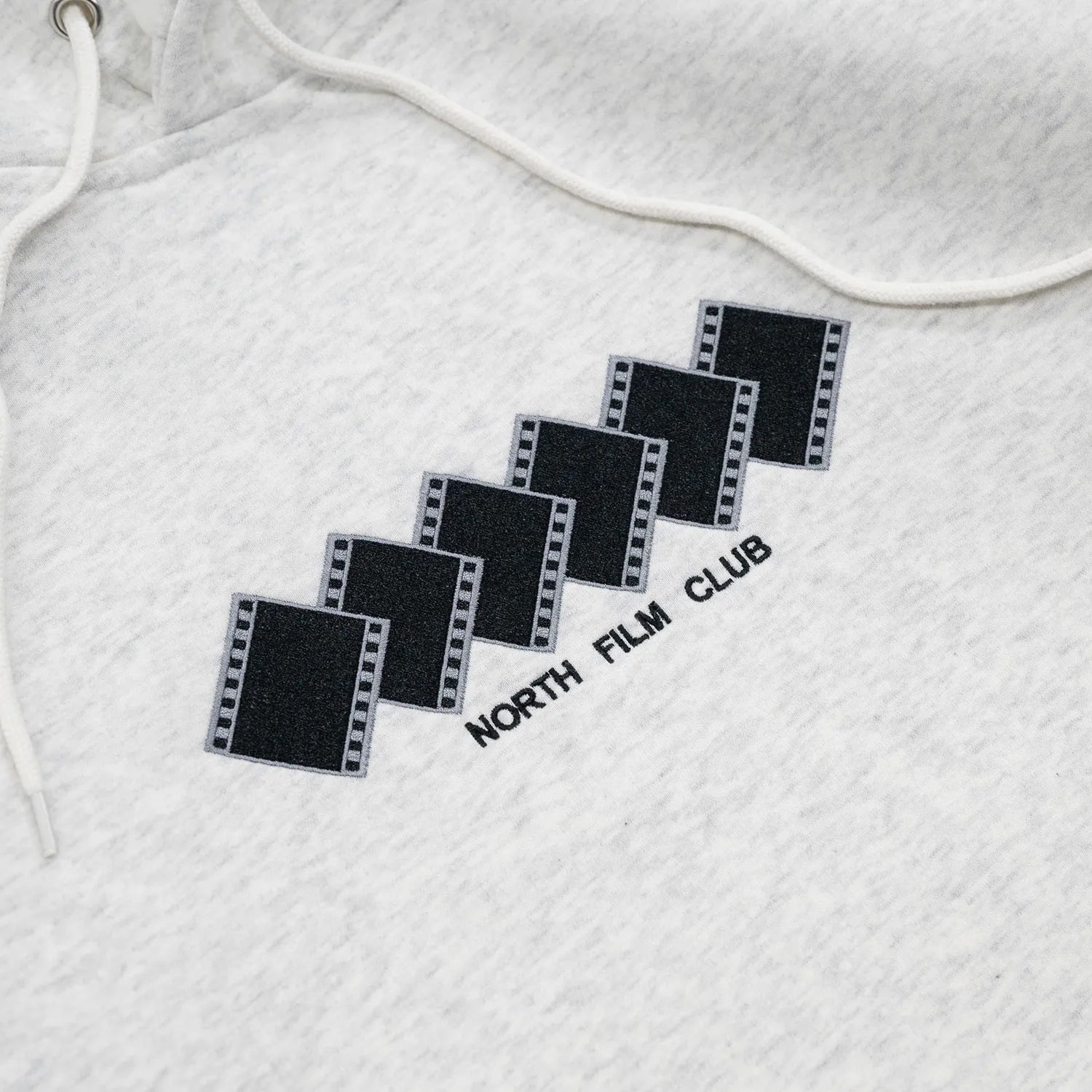 NORTH SKATE MAG(ノーススケートマグ)のフロントにデザインが刺繍で入る肉厚なパーカー「FILM CLUB HOODIE」のASHカラーの正面デザインの写真