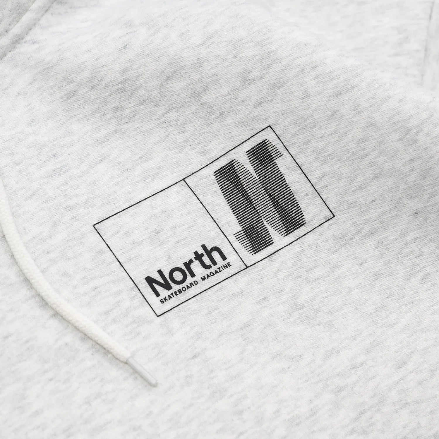 NORTH SKATE MAG(ノーススケートマグ)のバック大きく、フロント左胸にワンポイントでデザインがプリントされた肉厚なパーカー「N LOGO HOODIE」のASHカラーの襟元の写真