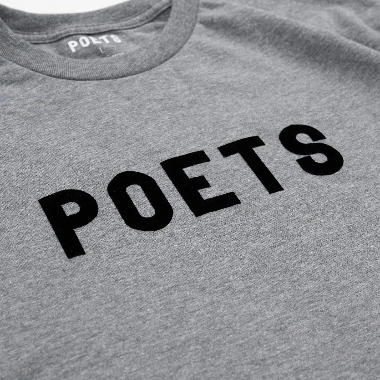 フロントにフェルト地のプリントデザインが入るPOETS(ポエッツ)のTシャツ「POETS OG POETS FLOCKED TEE」の「GRAPHITE/BLACK」カラーのフロントデザインの写真