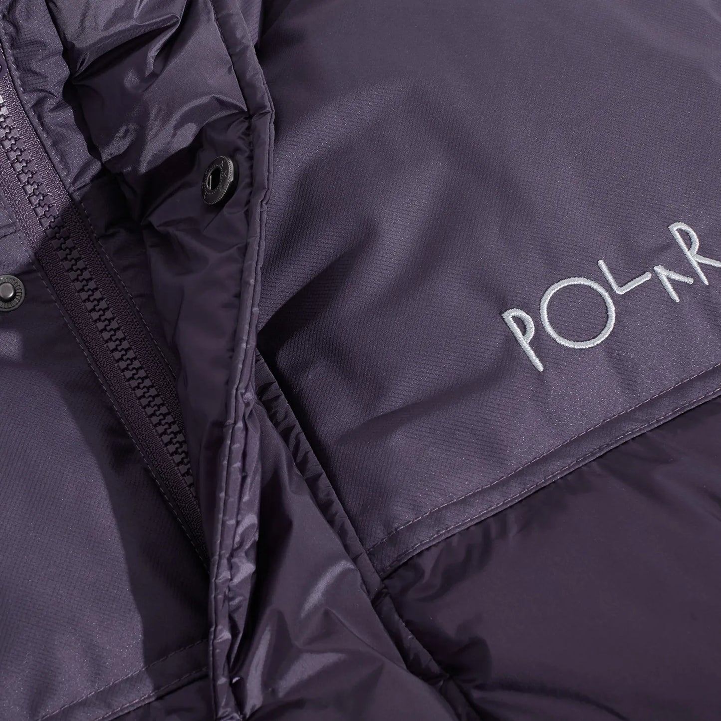 POLAR SKATE CO(ポーラースケート)の600フィルパワーのダウンベスト「BASIC PUFFER VEST」のDARK VIOLETカラーの正面胸元の写真