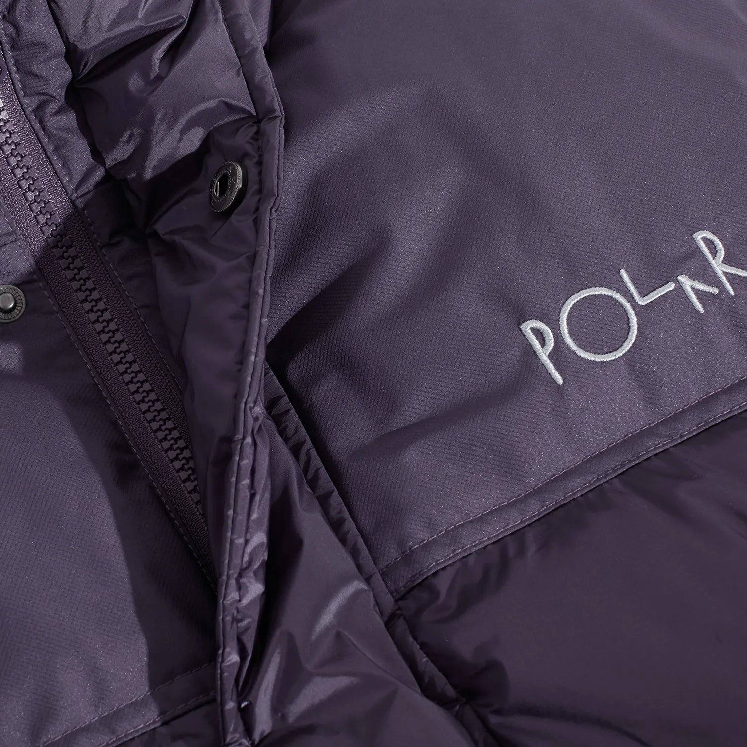 POLAR SKATE CO(ポーラースケート)の600フィルパワーのダウンベスト「BASIC PUFFER VEST」のDARK VIOLETカラーの正面胸元の写真