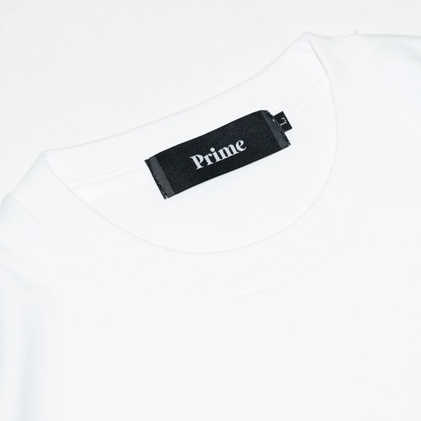 裾にドローコードがついたPrimeのTシャツ「PRIME GALLERY LOGO DRAWCORD TEE」のWHITEカラーの襟裏のブランドタグ
