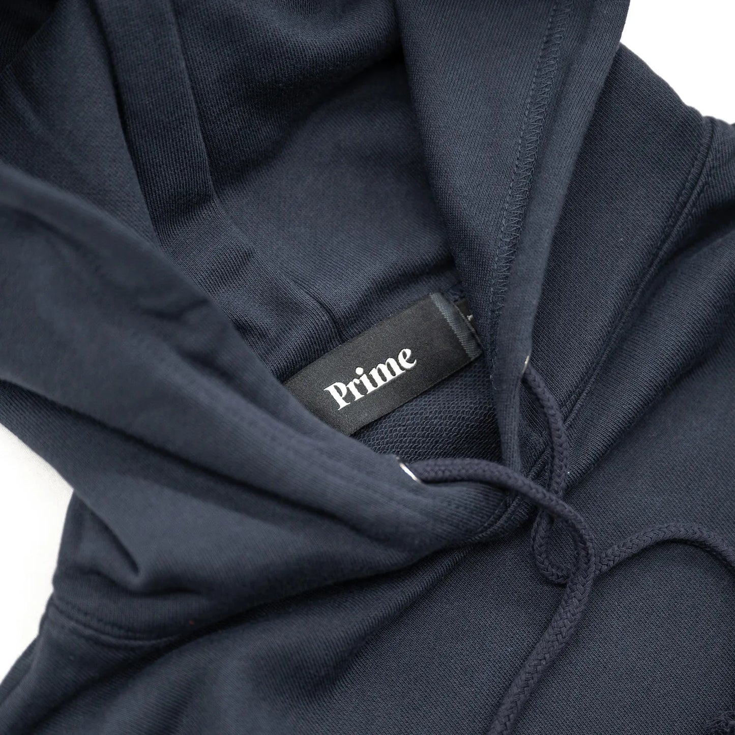 Primeのパーカー・フーディ「PRIME GALLERY BAR LOGO HOODY」のNAVYカラーの襟裏のブランドタグ