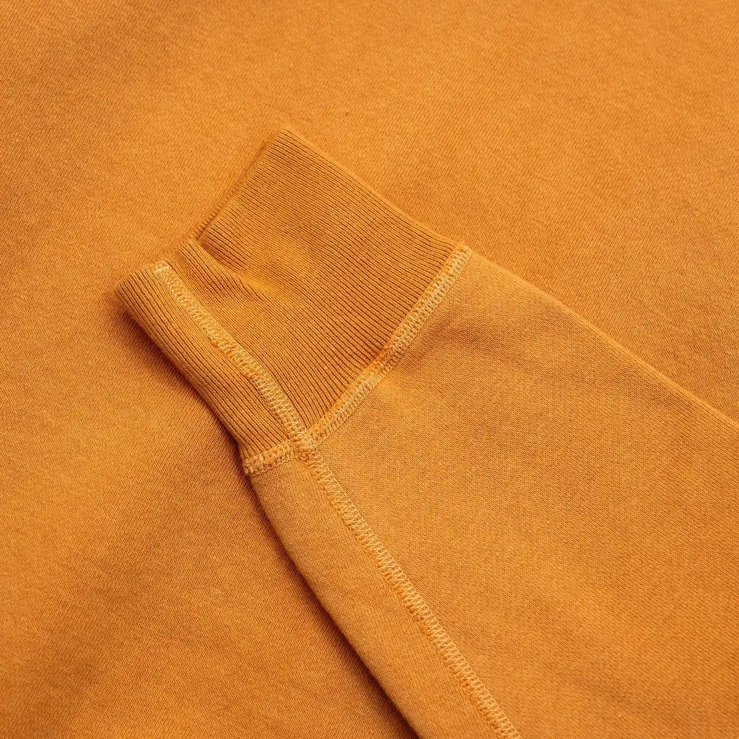 東洋エンタープライズが展開する人気ブランド「BUZZ RICKSON'S(バズリクソンズ)」のこだわりが詰まった定番クルーネックスエット「SET-IN CREW NECK SWEAT(BR65622)」のORANGEカラーの袖リブの写真