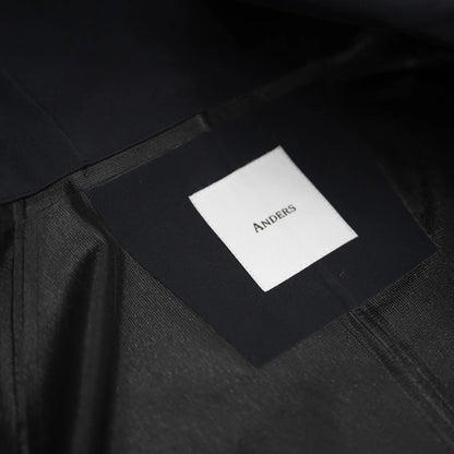 米軍の「ECWCS LEVEL6 JACKET GEN1 後期型」をベースにAndersが再構築したの3LAYERコート「3LAYERS ECWCS HARD SHELL COAT」のMATT BLACKカラーの襟裏ブランドロゴの写真
