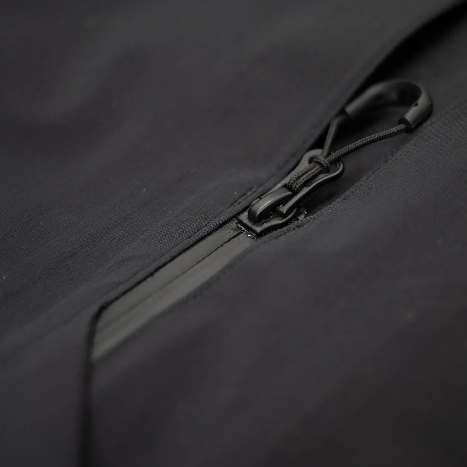 米軍の「ECWCS LEVEL6 JACKET GEN1 後期型」をベースにAndersが再構築したの3LAYERコート「3LAYERS ECWCS HARD SHELL COAT」のMATT BLACKカラーのジップアップ部分の写真
