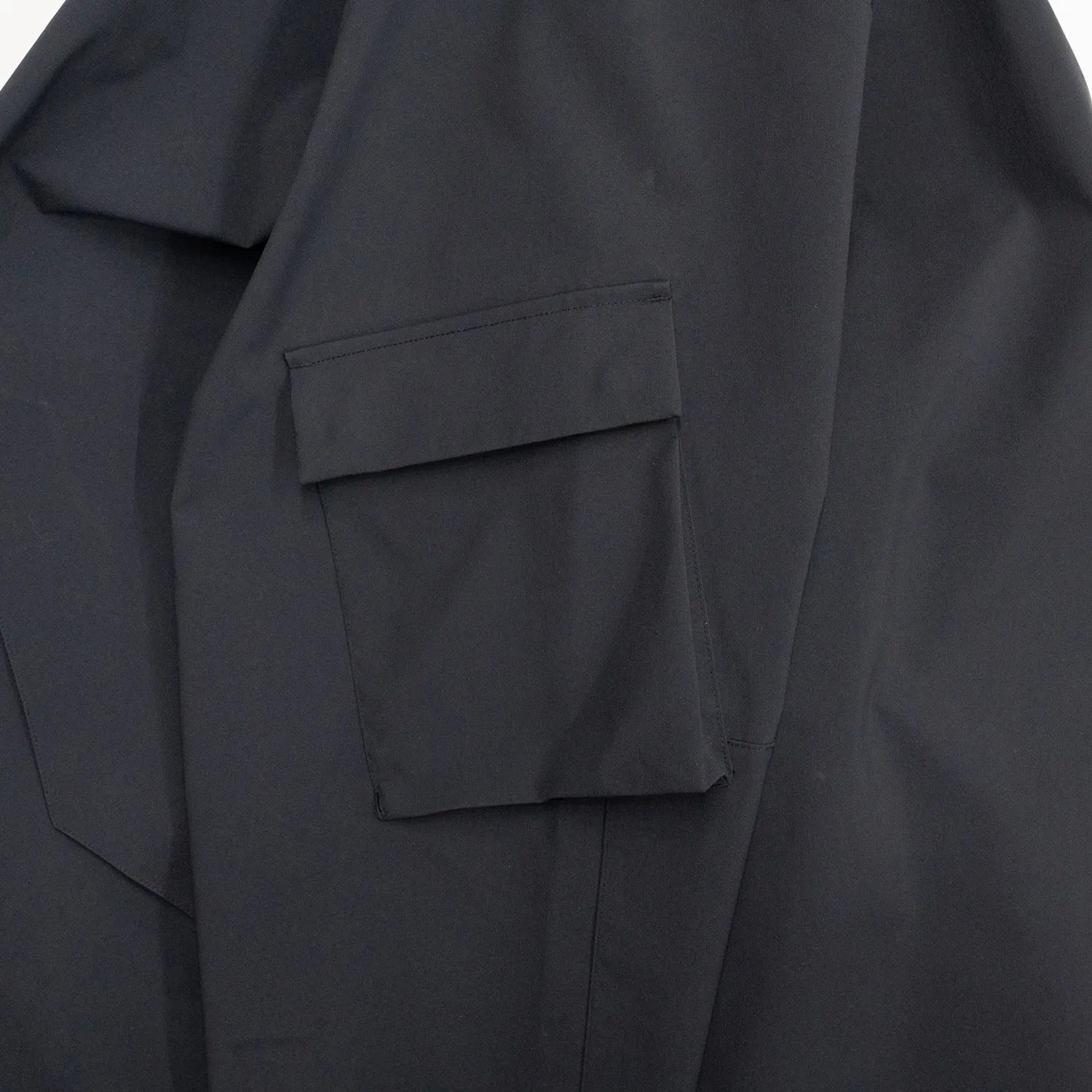 米軍の「ECWCS LEVEL6 JACKET GEN1 後期型」をベースにAndersが再構築したの3LAYERコート「3LAYERS ECWCS HARD SHELL COAT」のMATT BLACKカラーのスリーブポケットの写真
