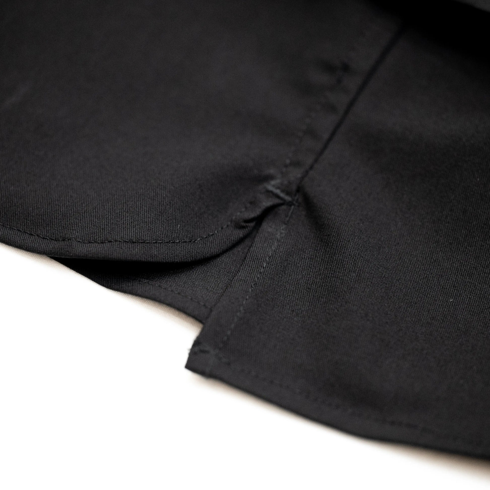 考え抜かれたワイドなボックスシルエットのAndersの傑作ドレープシャツ「WIDE DRAPE S/S SHIRTS」の「CROW」カラーの裾の部分のスリット加工の写真