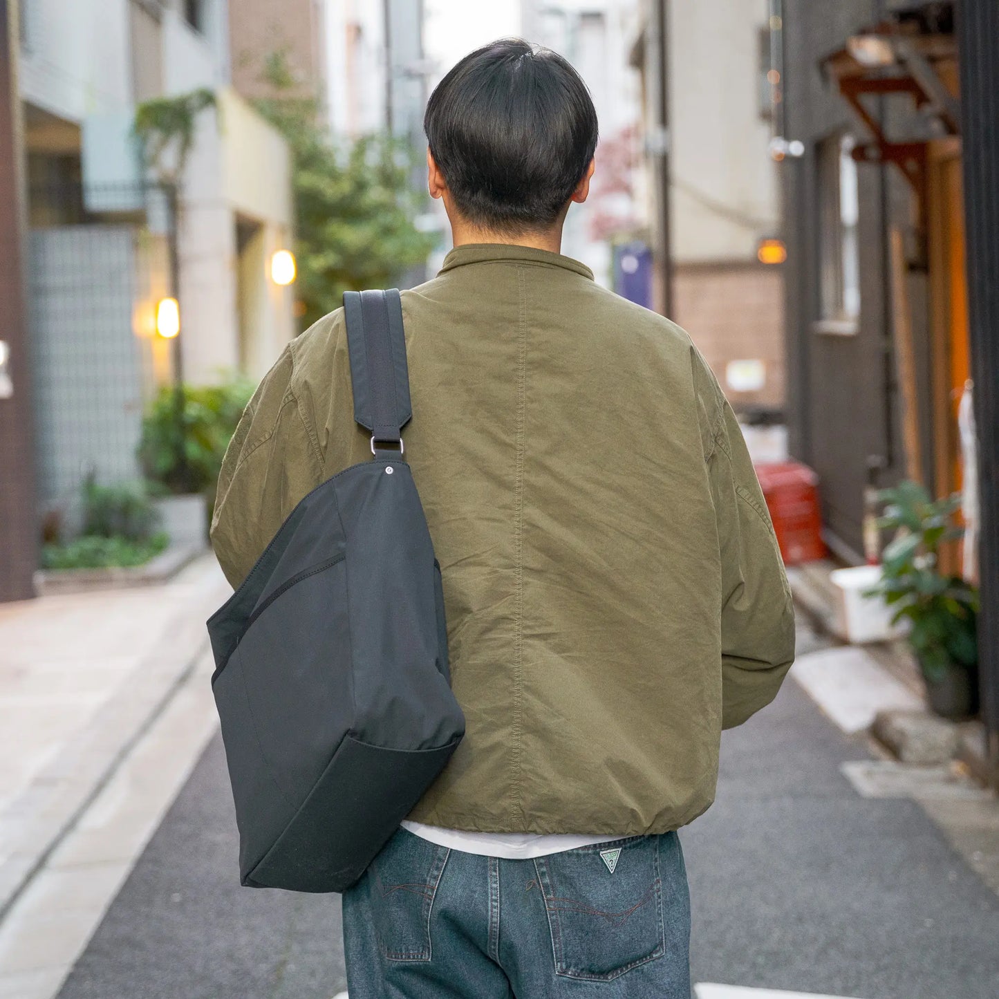 「TRIALOGUE STUDIO」のバッグ「ECLECTIC CROSSBODY BAG」を着用した背面から写真