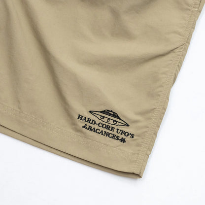 BACANCESのナイロン製の水陸両用ショーツ「BC NYLON SHORTS HARDCORE UFO'S LOGO」のCOYOTEカラーの左裾の刺繍デザインの写真