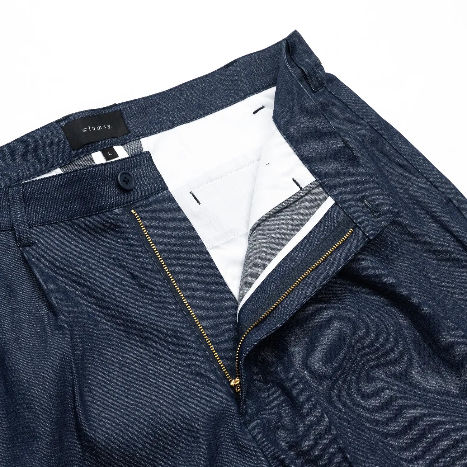 clumsy. PICTURES(クラムジーピクチャーズ)のノンウォッシュの薄手デニム生地を使用した新作パンツ「2 PLEATS WIDE DENIM SLACKS」のINDIGOカラーのフロントジップ部分の写真