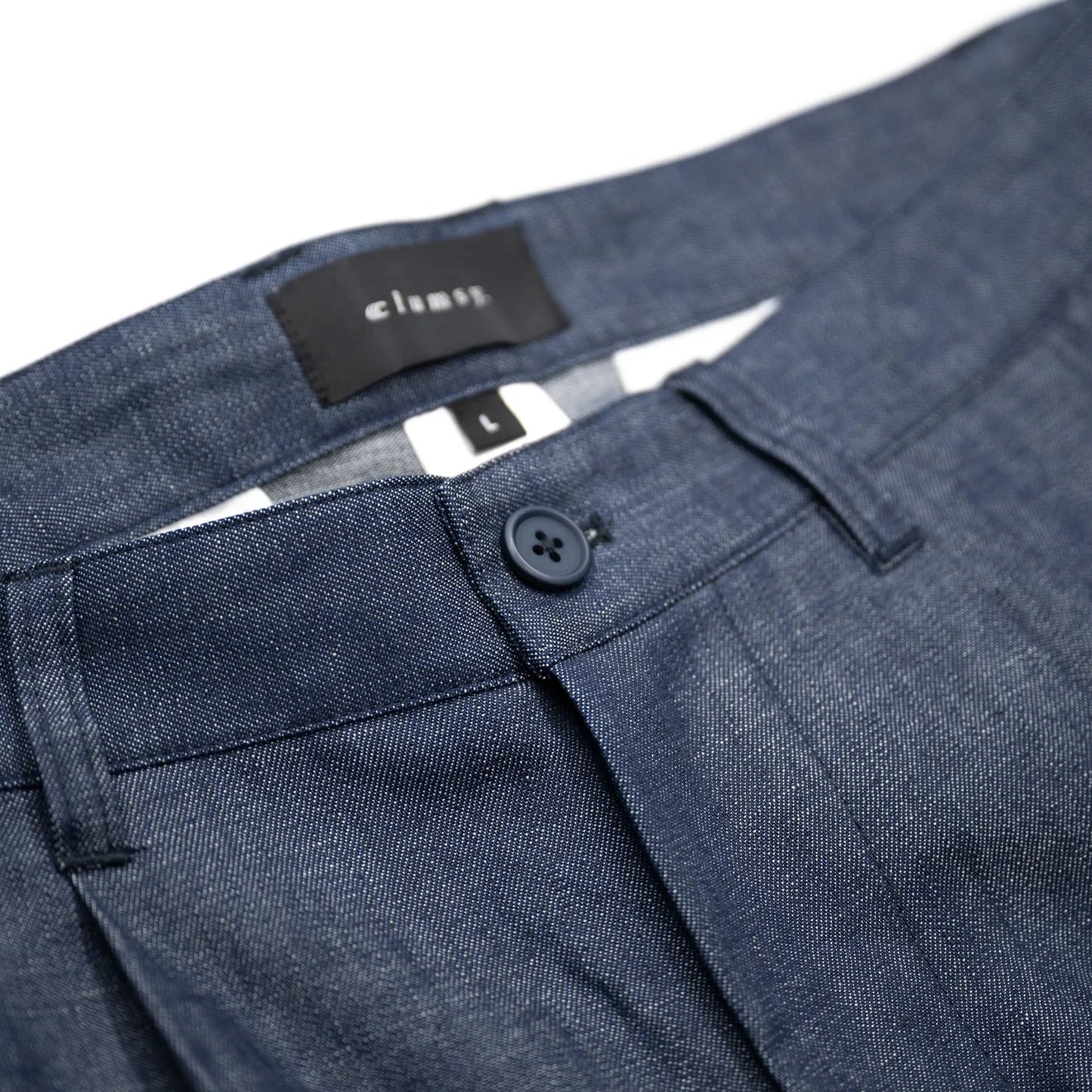 clumsy. PICTURES(クラムジーピクチャーズ)のノンウォッシュの薄手デニム生地を使用した新作パンツ「2 PLEATS WIDE DENIM SLACKS」のINDIGOカラーのウエストボタンの写真