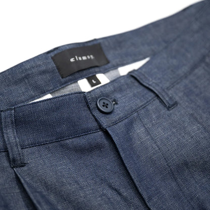 clumsy. PICTURES(クラムジーピクチャーズ)のノンウォッシュの薄手デニム生地を使用した新作パンツ「2 PLEATS WIDE DENIM SLACKS」のINDIGOカラーのウエストボタンの写真