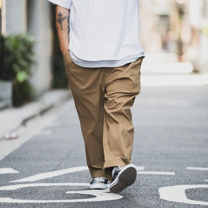 CLUMSY PICTURES(クラムジー)の名作パンツ「2 PLEATS RELAXED TWILL PANTS」の2025AWの新色「BROWNカラー」の正面からの歩きながらの着用写真