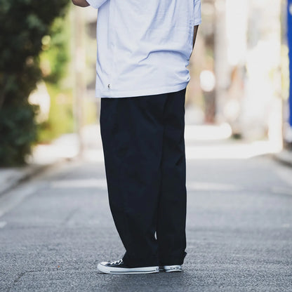 CLUMSY PICTURES(クラムジー)の名作パンツ「2 PLEATS RELAXED TWILL PANTS」の2025AWの新色「BROWNカラー」の左斜め後ろからの着用写真