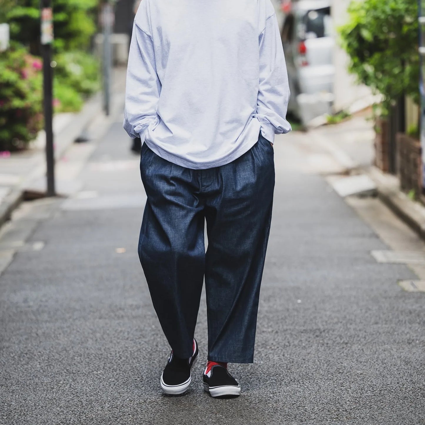 clumsy Picturesのノンウォッシュの軽いデニム生地の「2 PLEATS WIDE DENIM SLACKS」のINDIGOカラーの正面からの着用写真