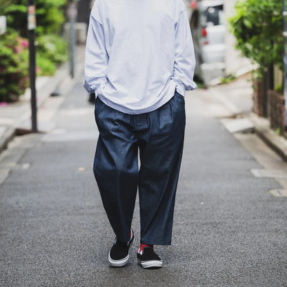 clumsy Picturesのノンウォッシュの軽いデニム生地の「2 PLEATS WIDE DENIM SLACKS」のINDIGOカラーの正面からの着用写真