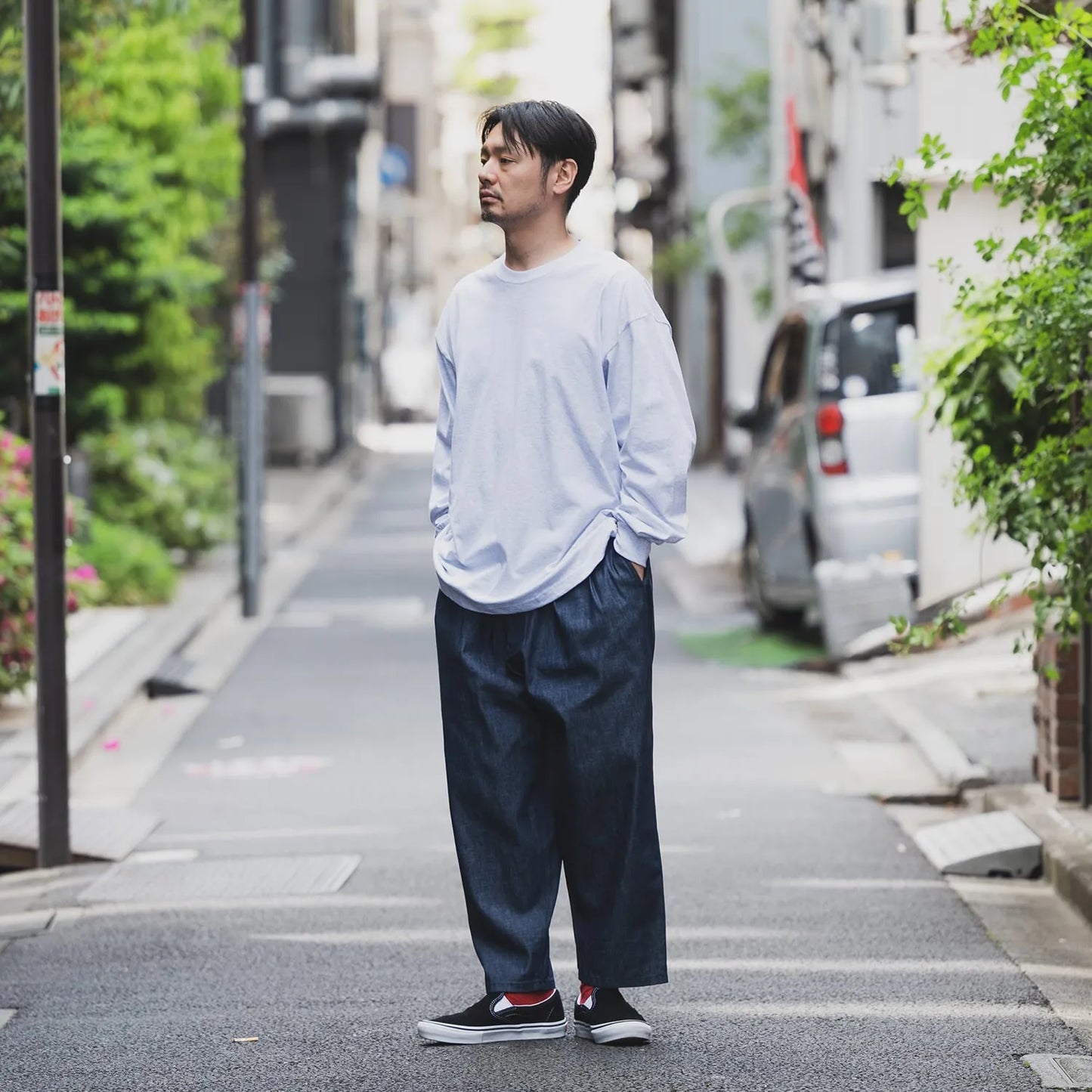 clumsy Picturesのノンウォッシュの軽いデニム生地の「2 PLEATS WIDE DENIM SLACKS」のINDIGOカラーの斜め前からの着用写真