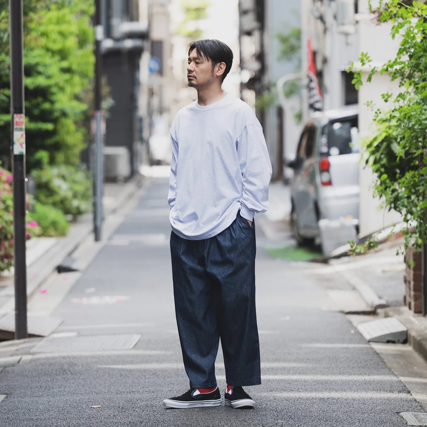 clumsy Picturesのノンウォッシュの軽いデニム生地の「2 PLEATS WIDE DENIM SLACKS」のINDIGOカラーの斜め前からの着用写真