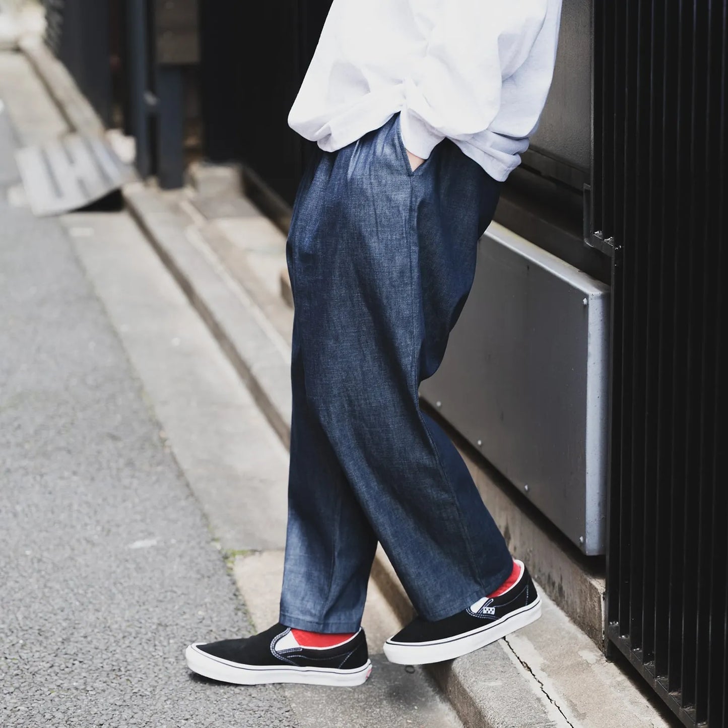 clumsy Picturesのノンウォッシュの軽いデニム生地の「2 PLEATS WIDE DENIM SLACKS」のINDIGOカラーの斜め前からの近接着用写真