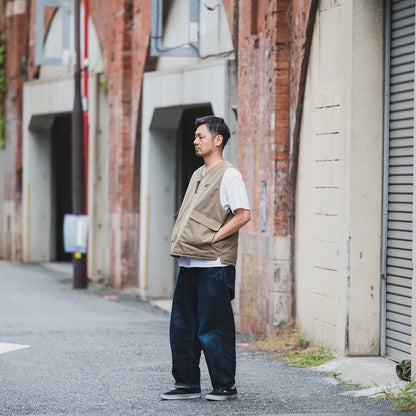clumsy. Pictures(クラムジー)の新作ベスト「TACTICAL DUCK VEST」のTANカラーのXLサイズの着用画像の別カット。モデルは178cm