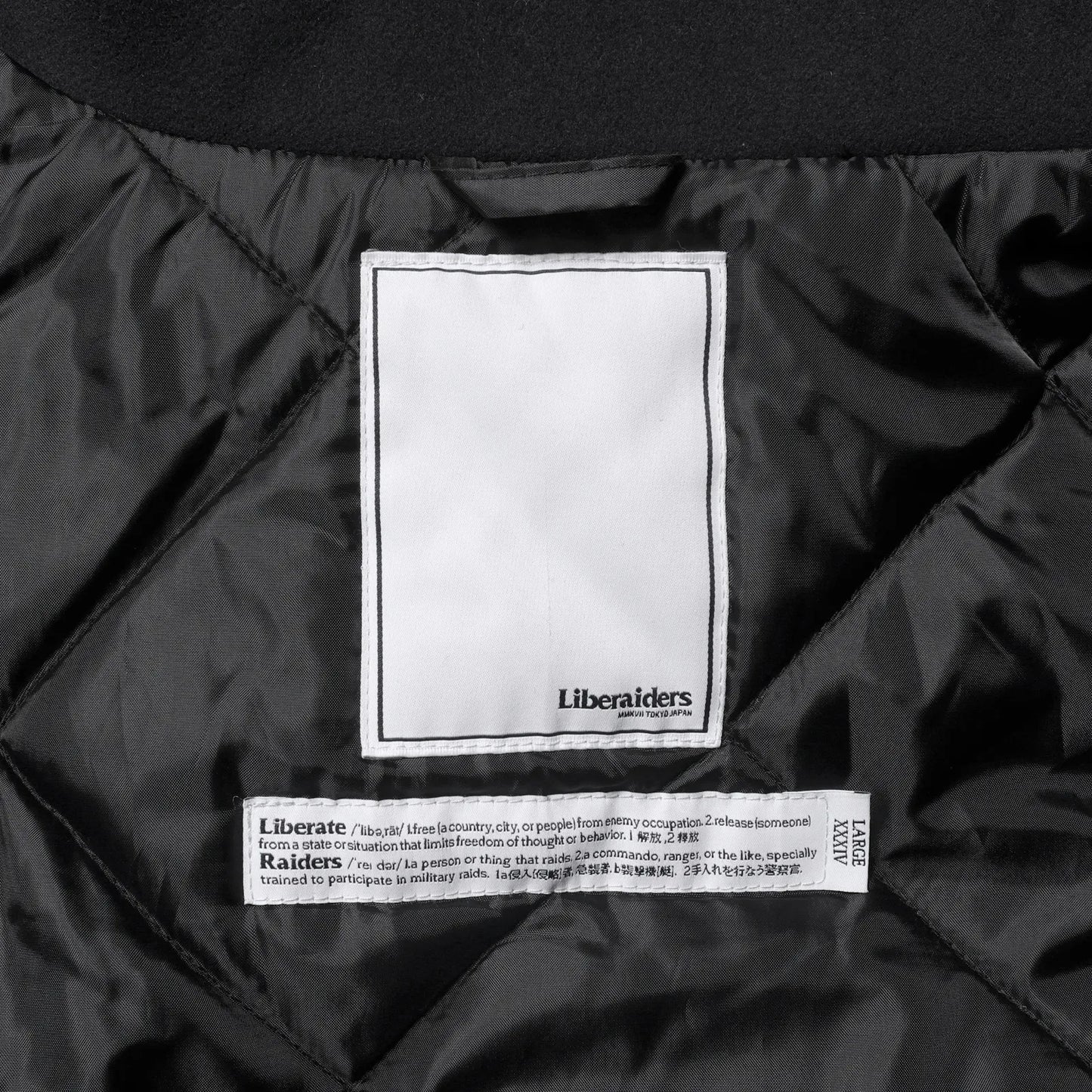 Liberaiders(リベレイダース)の肉厚なバーシティジャケット「LR VARSITY JACKET」のBLACKカラーの襟裏のブランドタグの写真