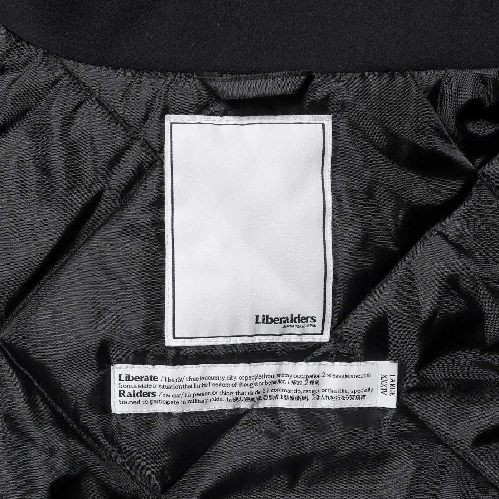 Liberaiders(リベレイダース)の肉厚なバーシティジャケット「LR VARSITY JACKET」のBLACKカラーの襟裏のブランドタグの写真