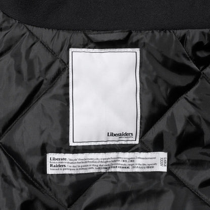 Liberaiders(リベレイダース)の肉厚なバーシティジャケット「LR VARSITY JACKET」のBLACKカラーの襟裏のブランドタグの写真