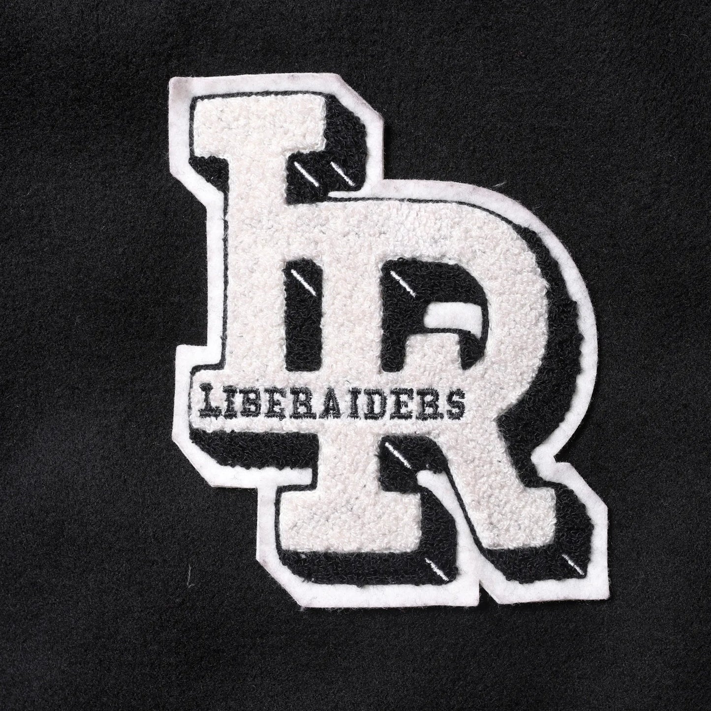 Liberaiders(リベレイダース)の肉厚なバーシティジャケット「LR VARSITY JACKET」のBLACKカラーの正面左胸のワッペンの写真