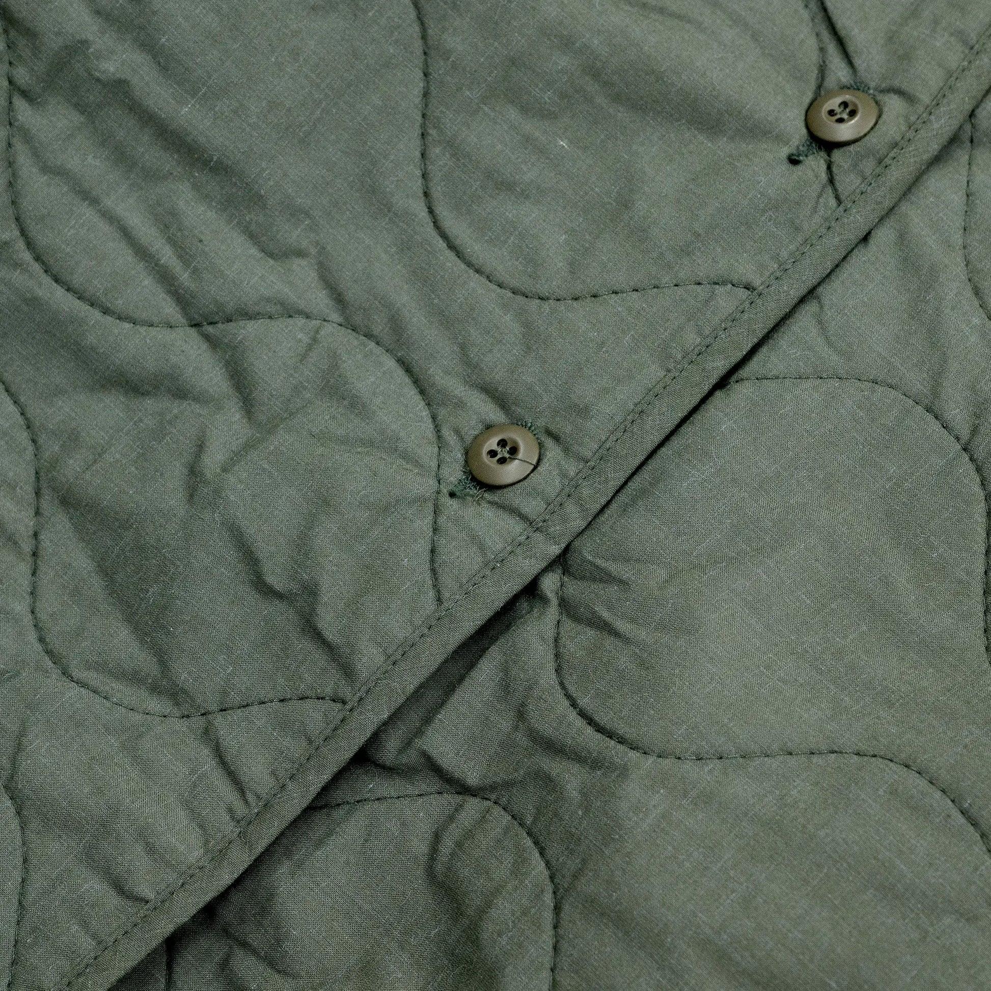 Primeが発掘したDEAD STOCKのVINTAGE「US ARMY AIRCREW NOMEX LINER JACKET / OLIVE DRAB」の前面のボタンの写真