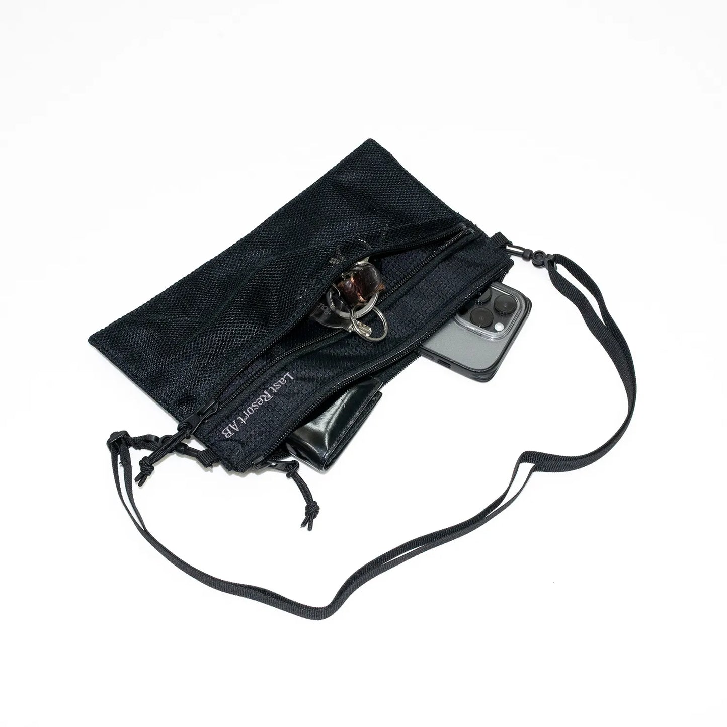 LAST RESORT ABのBLACKカラーのナイロン製小型ショルダーバッグ「LIFT OFF BAG」に小物を入れたイメージ写真