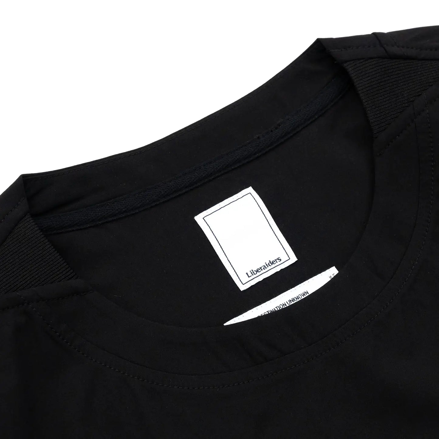 Liberaiders(リベレイダース)の撥水性のある4WAYストレッチ生地を使用したユーティリティTシャツ「4WAY STRETCH MULTI POCKET TEE」の BLACKカラーの襟裏のブランドタグ写真