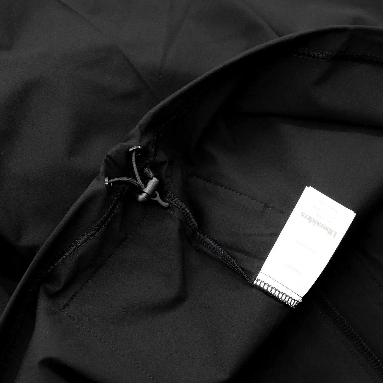 Liberaiders(リベレイダース)の撥水性のある4WAYストレッチ生地を使用したユーティリティTシャツ「4WAY STRETCH MULTI POCKET TEE」の BLACKカラーの裾のアジャスター写真