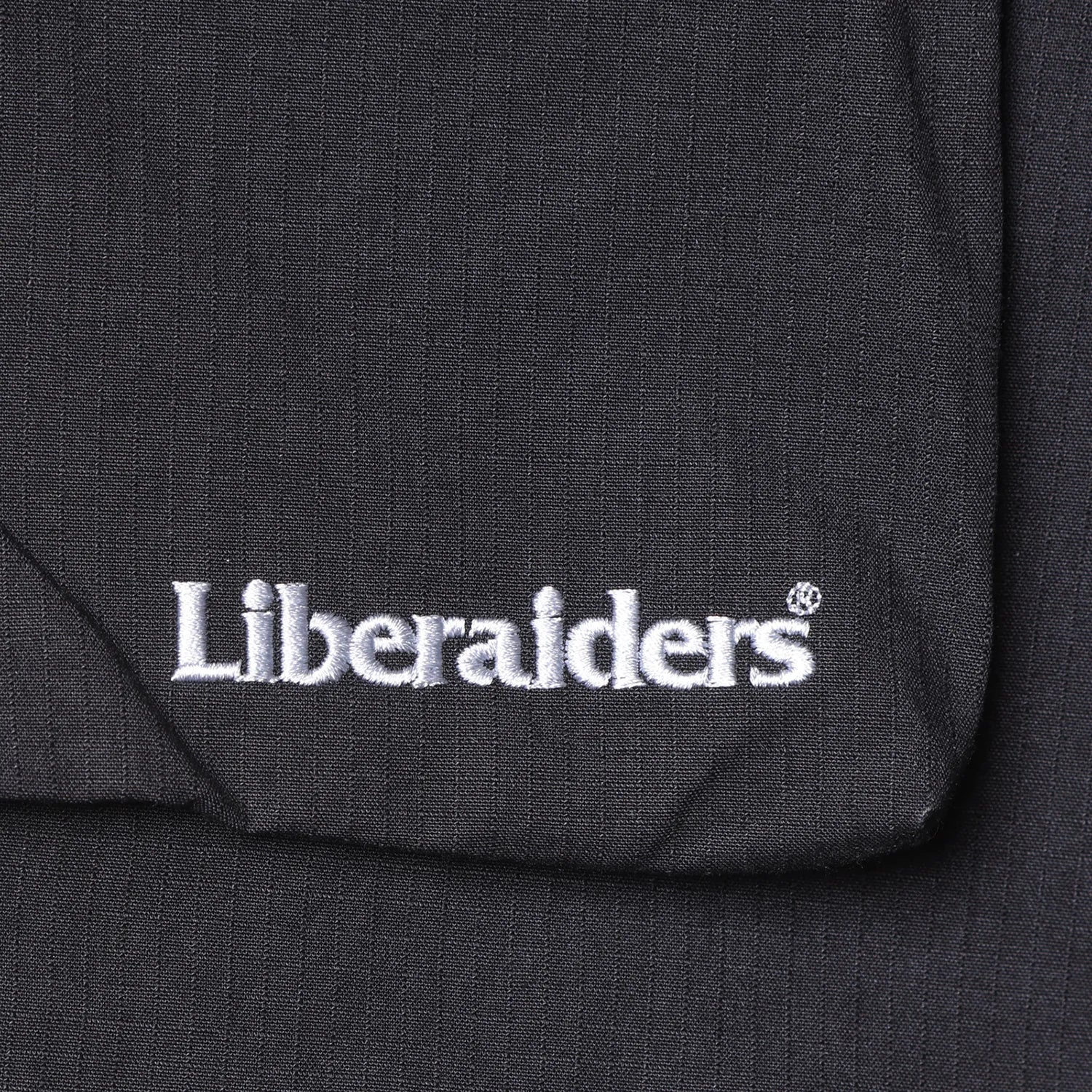 Liberaiders(リベレイダース)の高機能ナイロンショーツ「CORDURA RIP UTILITY SHORTS」のBLACKカラーの刺繍で入るブランドロゴの写真