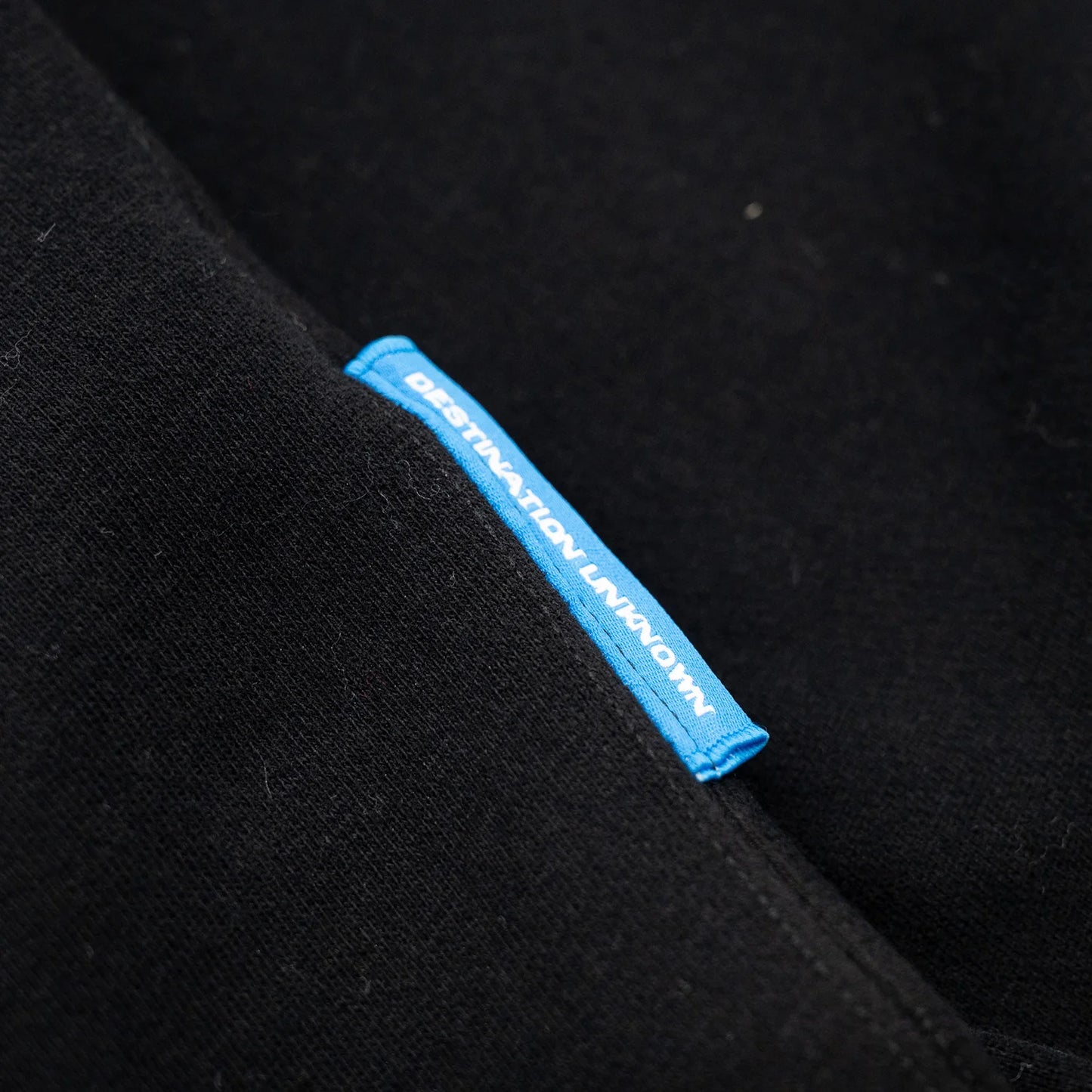 Liberaiders(リベレイダース)のフロントにデザインがプリントされた肉厚なフーディ(パーカー)「LR EMBROIDERY HOODIE」のBLACKカラーの左脇下のブランドタグの写真