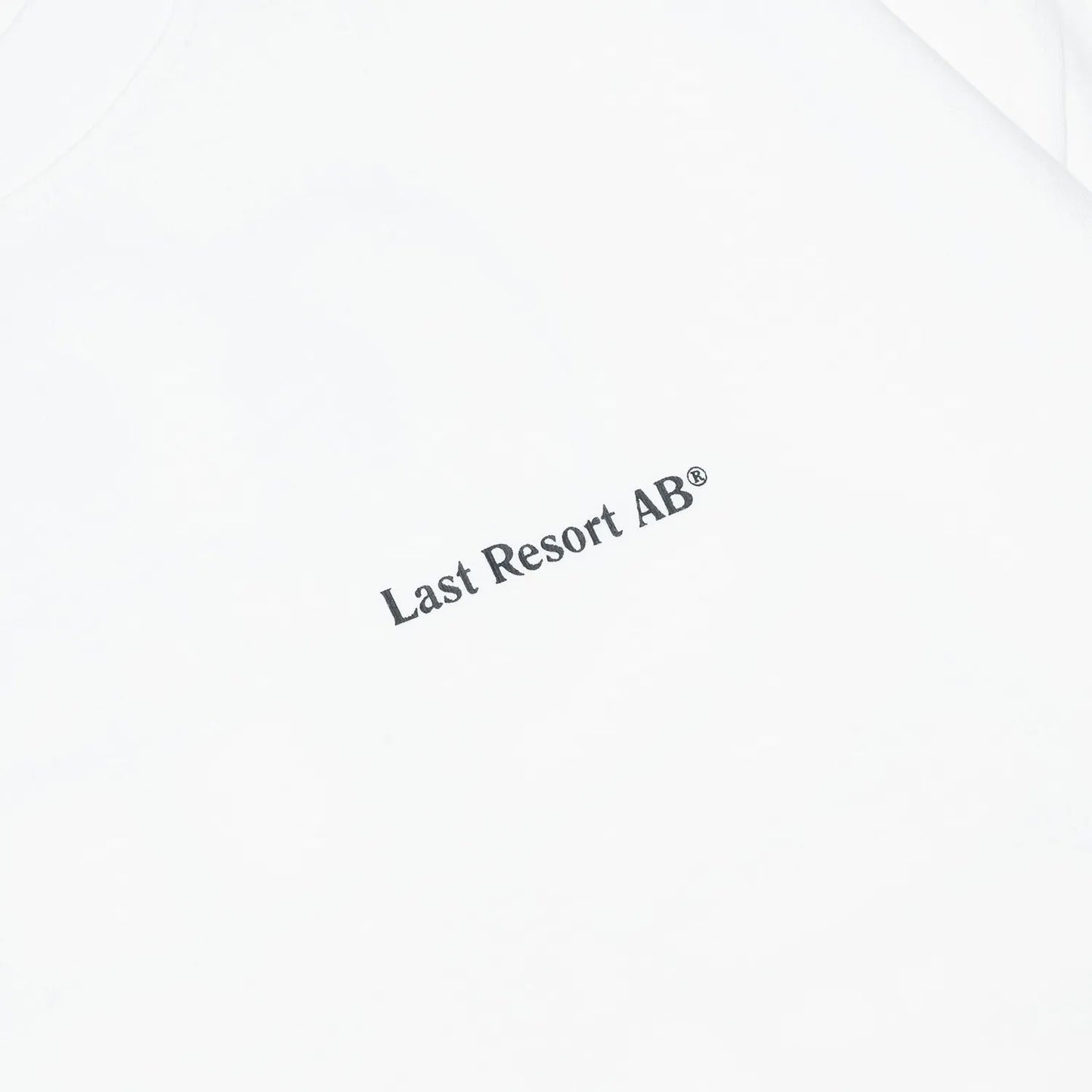 LAST RESORT ABのATLASロゴが背面にプリントされた定番のTシャツ「AB ATLAS MONOGRAM TEE」のWHITEカラーの正面左胸のデザイン写真