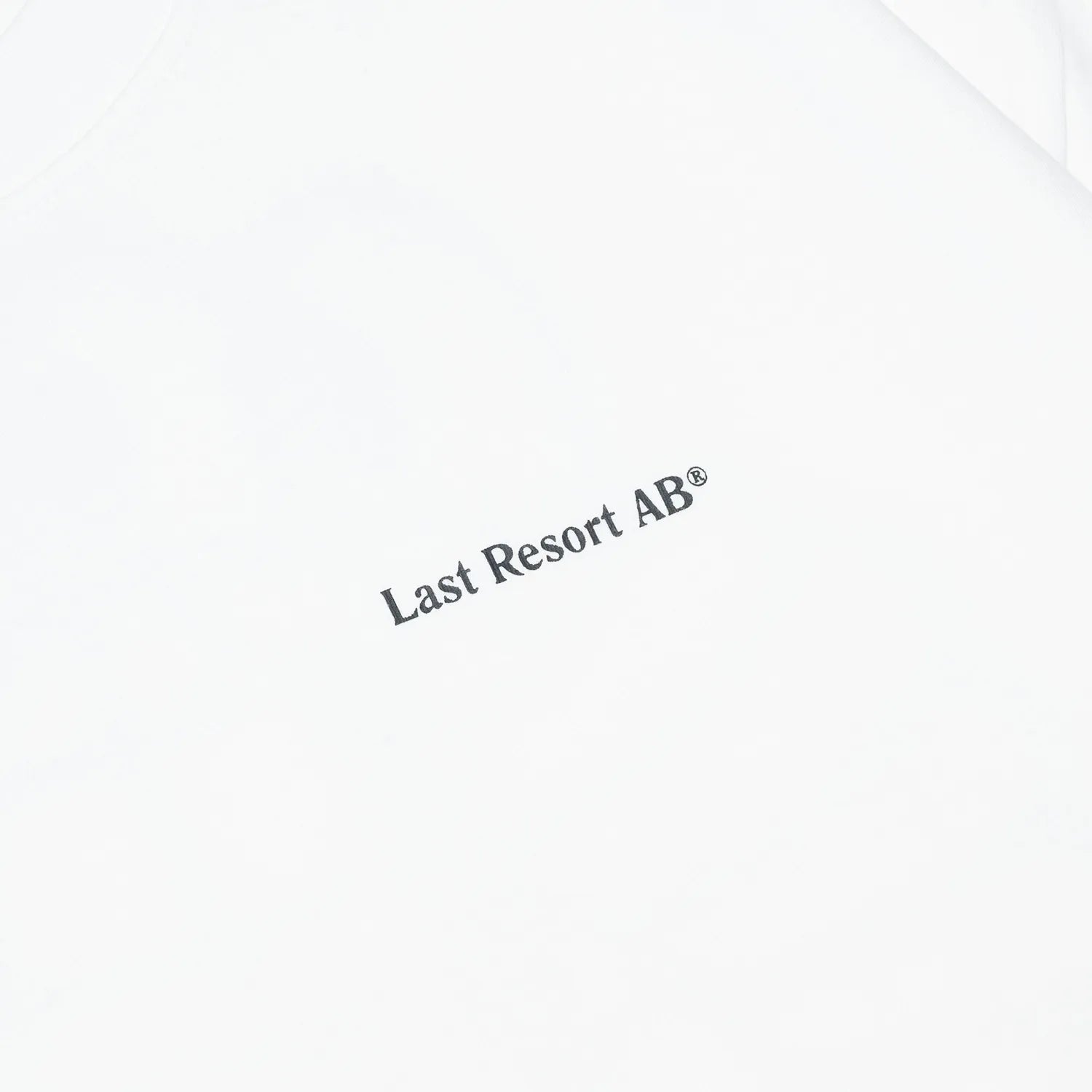 LAST RESORT ABのATLASロゴが背面にプリントされた定番のTシャツ「AB ATLAS MONOGRAM TEE」のWHITEカラーの正面左胸のデザイン写真