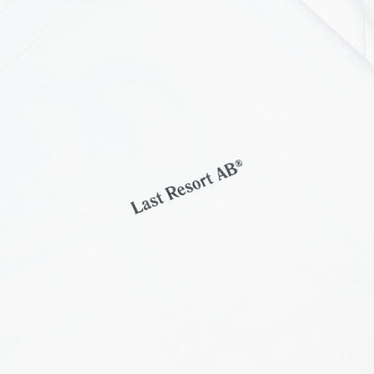 LAST RESORT ABのATLASロゴが背面にプリントされた定番のTシャツ「AB ATLAS MONOGRAM TEE」のWHITEカラーの正面左胸のデザイン写真