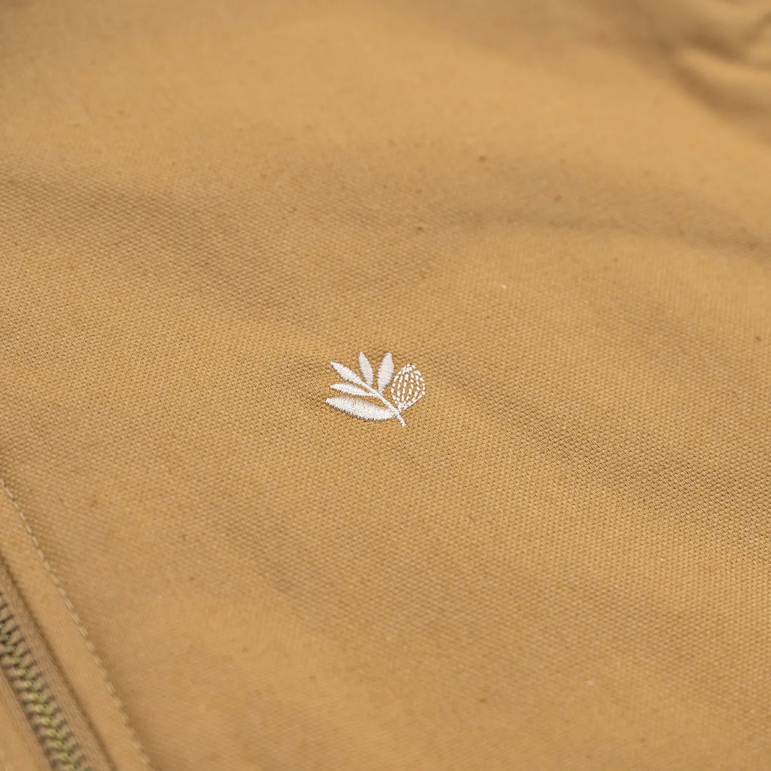 表地はコットンキャンバス、裏地にキルティングを配したMagenta(マジェンタ)のベスト「BUILD CANVAS VEST」のOCRAカラーの左胸のPLANTロゴのワンポイント刺繍の写真